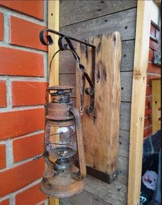 an old fashioned lantern hanging on the side of a brick wall next to a wooden door