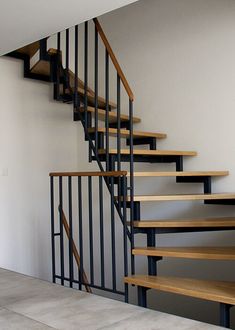 a set of stairs with wooden treads in an empty room next to a white wall