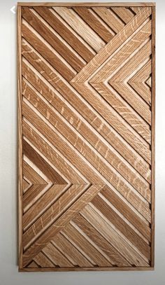 a wooden wall hanging on the side of a white wall with an arrow pattern in it