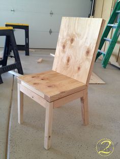 a wooden chair sitting on top of a floor next to a ladder and other tools