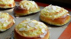 several baked desserts sitting on top of a baking pan covered in coconut flakes