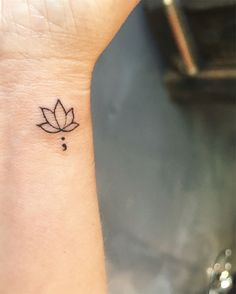 a small lotus tattoo on the wrist