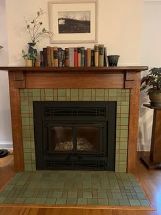 a fireplace with some books on top of it and a potted plant in the corner