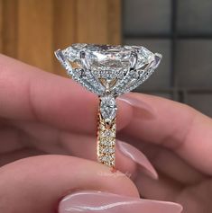 a person holding a diamond ring in their hand