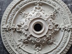 an ornate white ceiling medallion on the wall