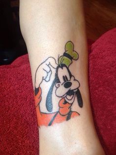 a person with a mickey mouse tattoo on their foot