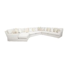 a white sectional couch with pillows on it's back and side facing the camera