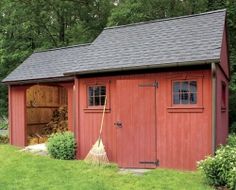 a red shed with a broom in the yard