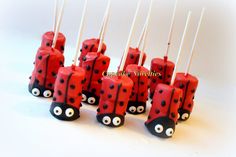 a group of red and black ladybug candles with sticks sticking out of them