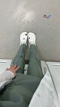 the person is wearing white shoes and green pants