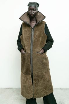 100% shearling sheep fur with 100% vegetable dyed leather/ long vest/ zipper closure/ front pockets/ high collar Amam is 5'9" size 2 wearing size S Fall Sheepskin Sleeveless Vest, Sleeveless Sheepskin Vest For Fall, Vest Zipper, Womens Outerwear, Luxury Outerwear, Shearling Vest, Long Vest, Accessories Bags Shoes, Knit Bottom