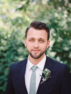 a man wearing a suit and tie with a boutonniere on his lapel