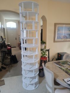 there is a tall white spiral shelf in the living room