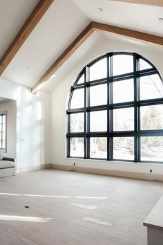 an empty living room with large arched windows