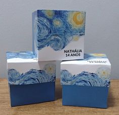 three boxes that are sitting on a wooden table and one is painted like the starry night