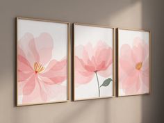 three pink flowers are hanging on the wall next to each other in an empty room