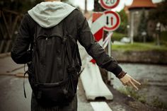 a man walking down the street with his back to the camera and holding his hands out