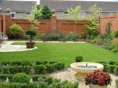 a garden with lots of green grass and plants in the center, surrounded by brick buildings