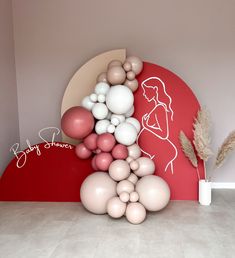 there is a balloon sculpture on the floor in front of a red wall with white and pink balloons