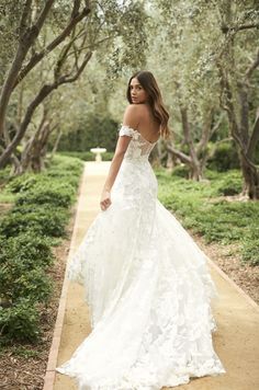 a woman in a wedding dress standing on a path