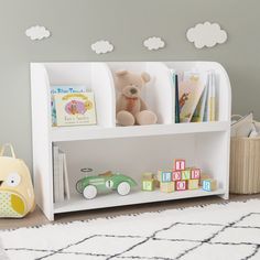 a white book shelf with toys and books on it in a child's room