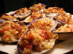 a plate full of cooked oysters on a white platter with crumbs