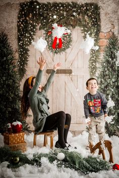 two children are playing in the snow with their hands up and one child is sitting on a bench