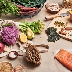 various foods are laid out on the table to be prepared and eaten for consumption, including broccoli, cauliflower, carrots, as well as well as other ingredients