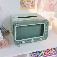 a green microwave oven sitting on top of a white shelf next to a teddy bear