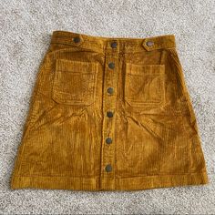 Madewell Corduroy A-Line Mini Skirt: Patch Pocket Edition New With Tags Size 4 (27) Exposed Button Front Beautiful Golden Marigold Yellow “In Supersoft Wide-Wale Corduroy, This Button-Front A-Line Mini Skirt Has Retro Details Like Patch Pockets And Waistband Tabs For A Low-Key '70s Vibe. Top It Off With A Half-Tucked Sweater For An Allover Cozy Look.” 17" Long. Cotton/Elastane. Tucked Sweater, Long Ruffle Skirt, Button Front Mini Skirt, Madewell Skirt, Marigold Yellow, Floral Pleated Skirt, Flared Mini Skirt, Black Denim Skirt, Pocket Edition