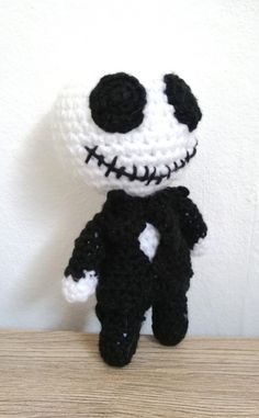 a crocheted jack skellingy doll sitting on top of a wooden table