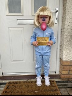 a doll is standing in front of a door with a sign on it's nose