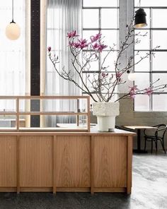 an empty restaurant with wooden counter tops and flowers in vases on the table next to it