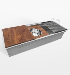 a stainless steel sink with wooden cutting board and strainer on the bottom, in front of a white background