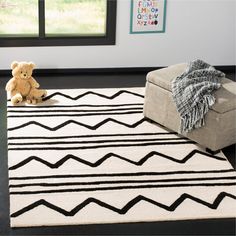 a black and white rug with a teddy bear on it in front of a window