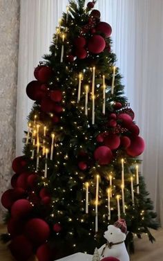 a christmas tree decorated with red balls and candles