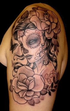 a woman's shoulder with flowers and a skull on the side, in black and white