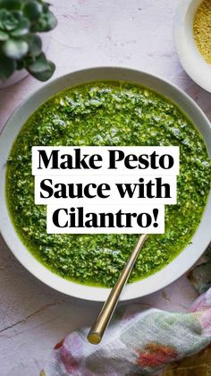 a white bowl filled with green pesto next to two bowls of seasoning and spices