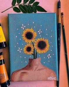 a painting with sunflowers on it next to some markers and paintbrushes