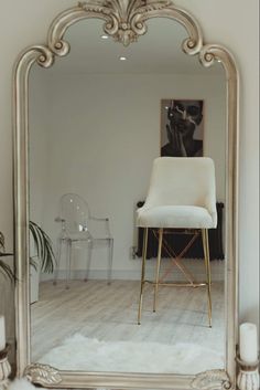 a white chair sitting in front of a large mirror