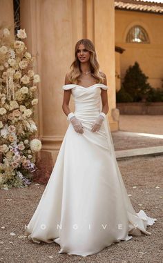 a woman in a white wedding dress standing outside