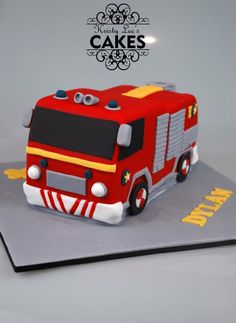 a cake that is shaped like a firetruck on top of a card board