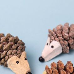 three hedgehogs made out of pine cones on a blue background