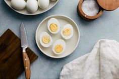 an overhead view of eggs and other ingredients on a plate next to a cutting board