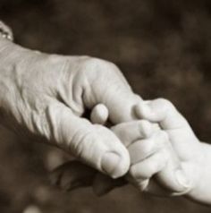 an older person holding the hand of a young child's hand in black and white