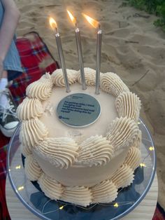 a white cake with three candles on it