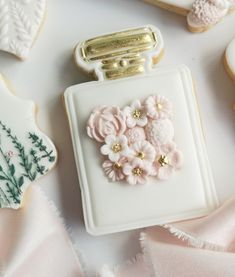 some cookies are sitting on a plate with flowers in the shape of hearts and an object that looks like a purse