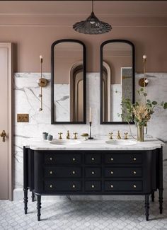 a bathroom with two sinks and mirrors on the wall