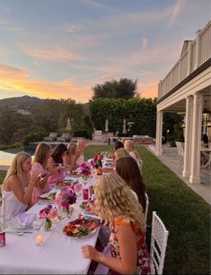 a group of women sitting around a table eating food