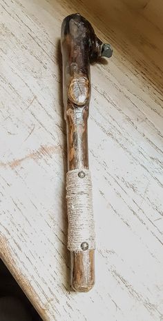 a piece of wood sitting on top of a wooden table next to a bottle opener